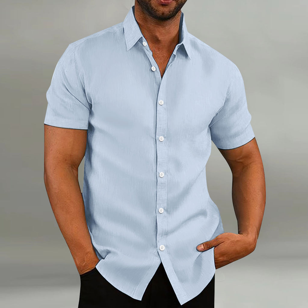 Man wearing a light blue short-sleeve shirt against a neutral background
