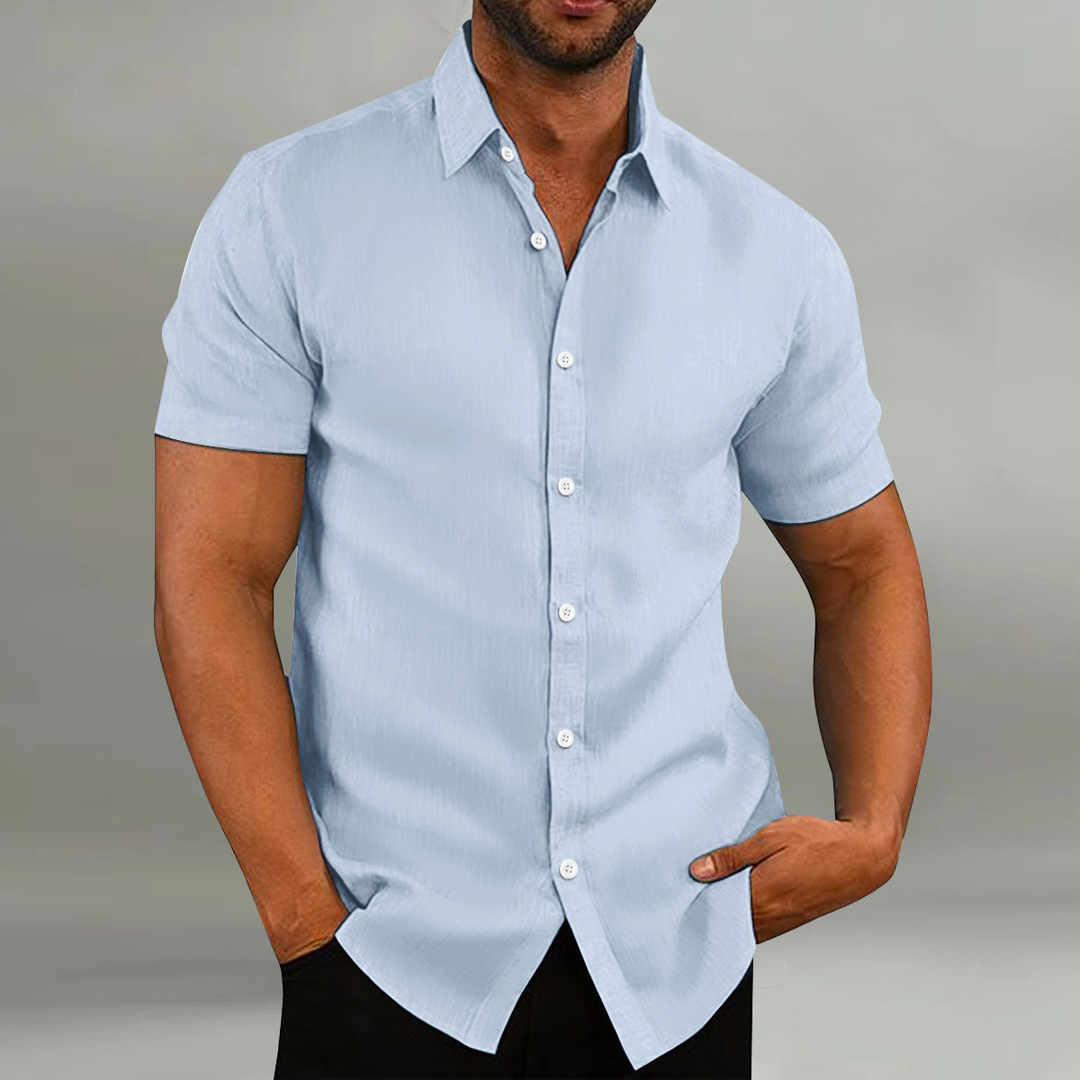 Man wearing a light blue short-sleeve shirt against a neutral background