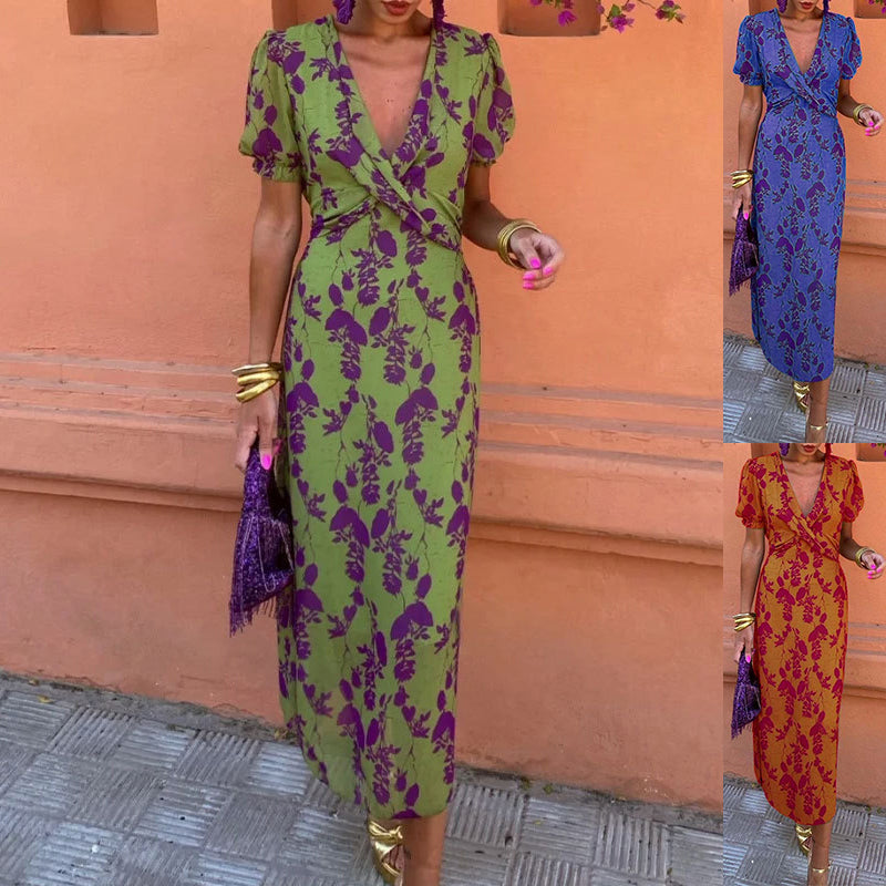 Woman wearing a green and purple floral dress against an orange wall.