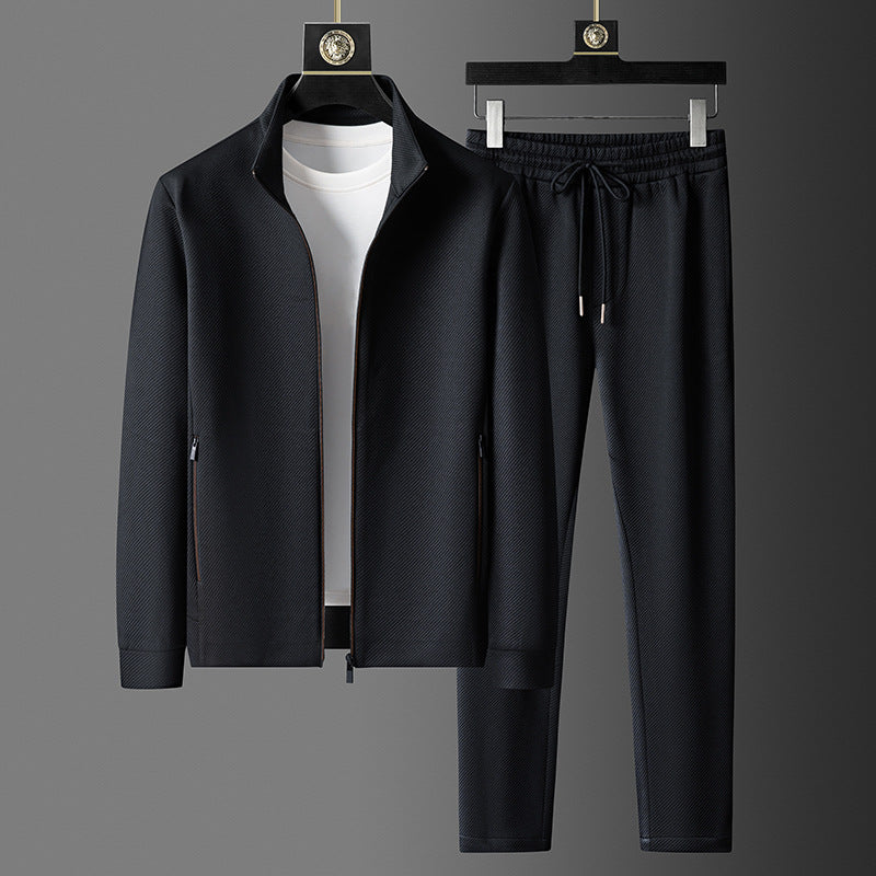 Men's black tracksuit set with zip-up jacket, drawstring pants, and white t-shirt on hangers