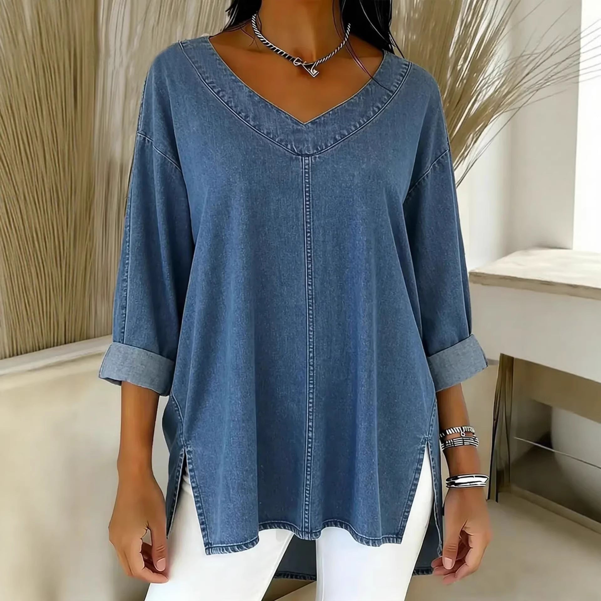 Person wearing a blue denim shirt with a neutral background