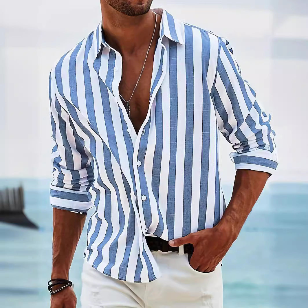 Man wearing a blue and white striped shirt with a blurred beach background