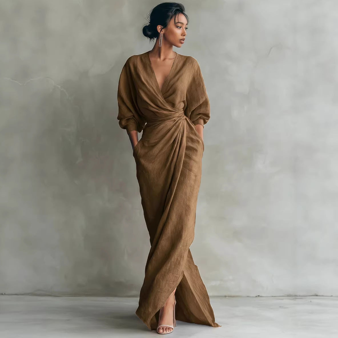 Woman wearing a brown draped dress against a plain background