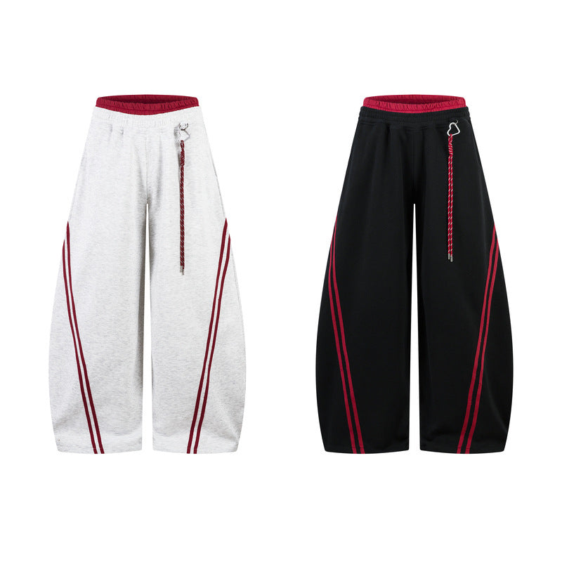 Two pairs of wide-leg pants, one white and one black, with red accents on a white background.