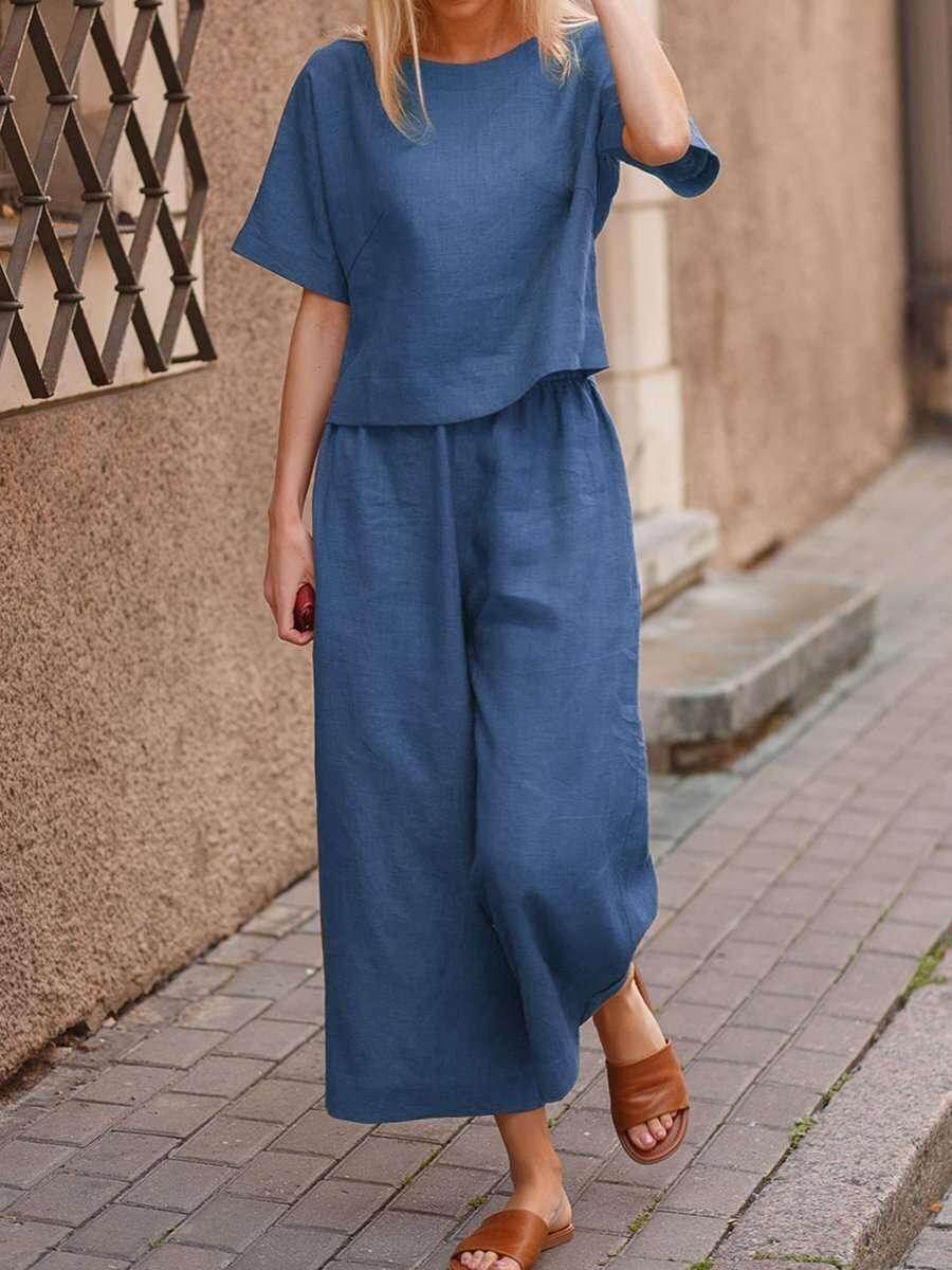 Woman wearing a blue linen two-piece outfit and brown sandals on a city street, ZA-Zola fashion