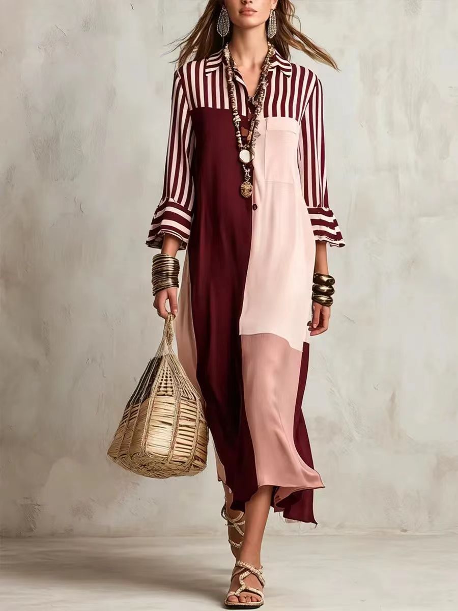 Woman wearing a striped shirt and layered dress holding a woven bag against a neutral background