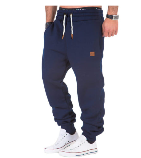 Navy blue jogger pants with a brand logo on a white background