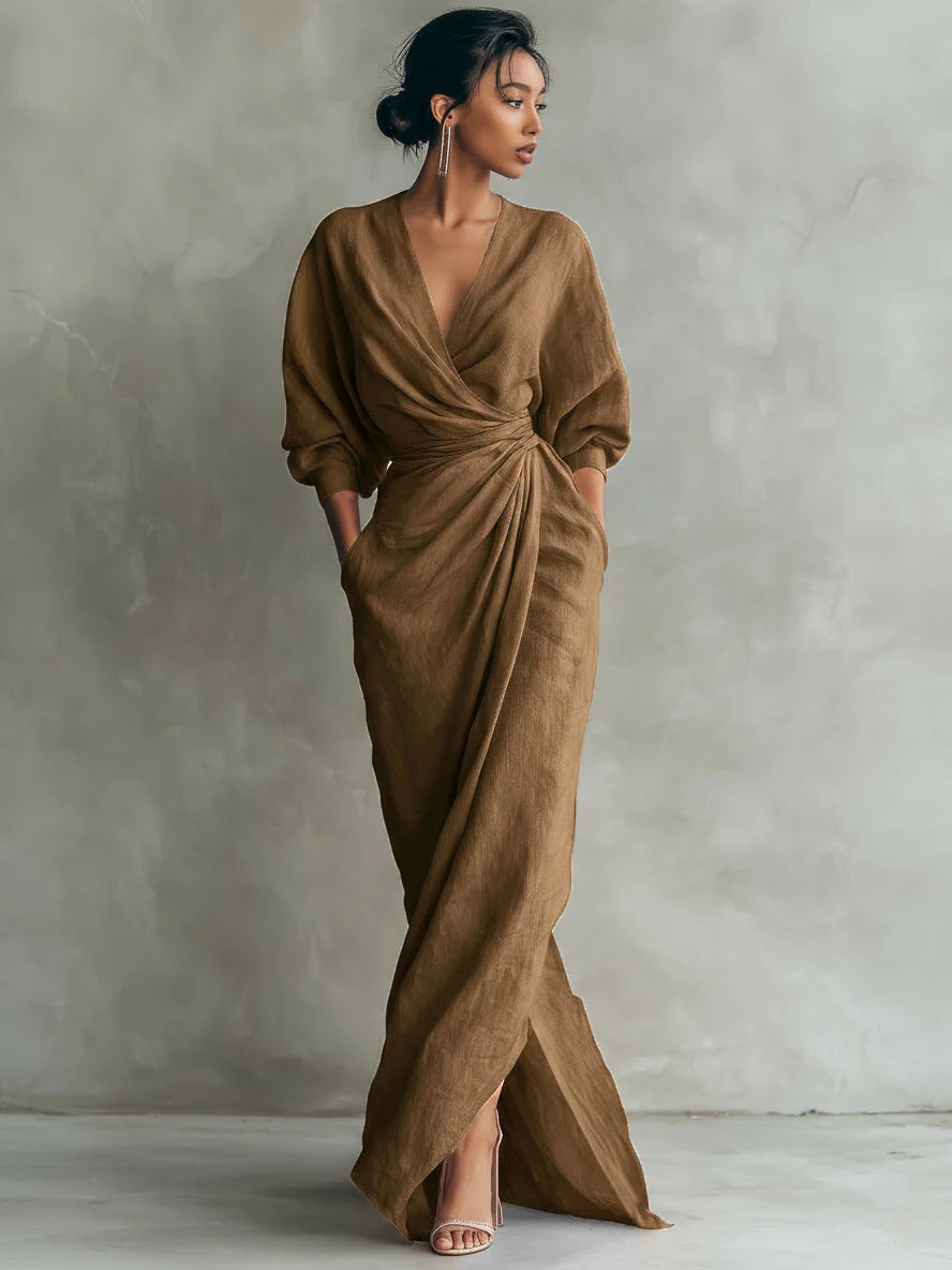 Woman wearing a brown draped dress against a plain background