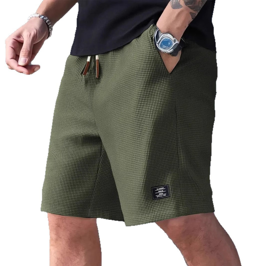 Person wearing green checkered shorts on a white background