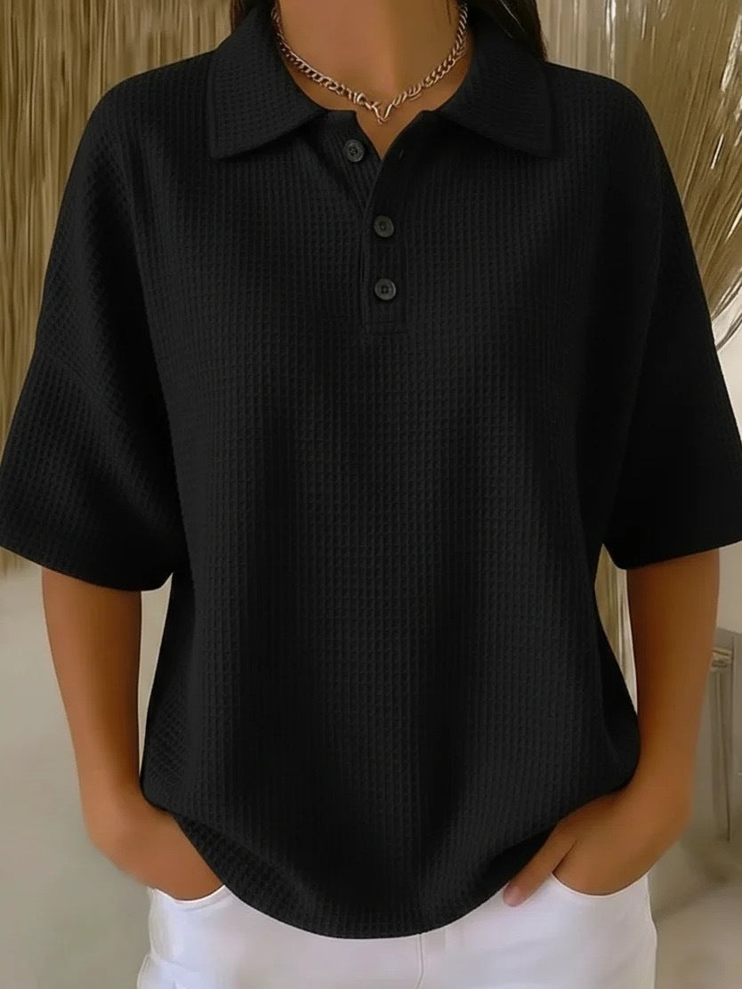 Black textured polo shirt worn by a person with a neutral background