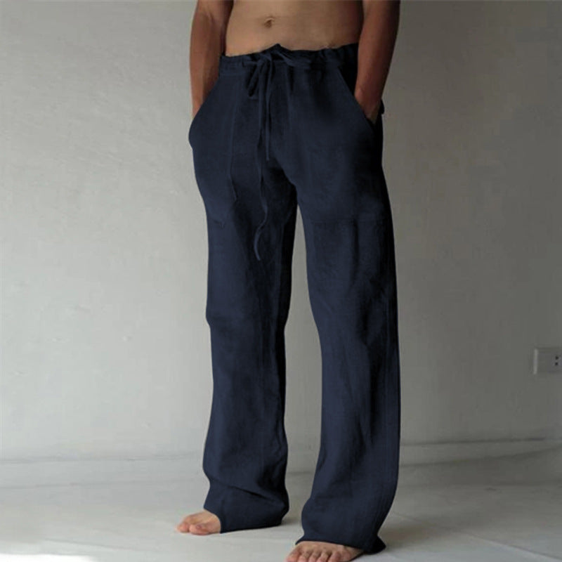 Person wearing navy blue drawstring pants against a plain background