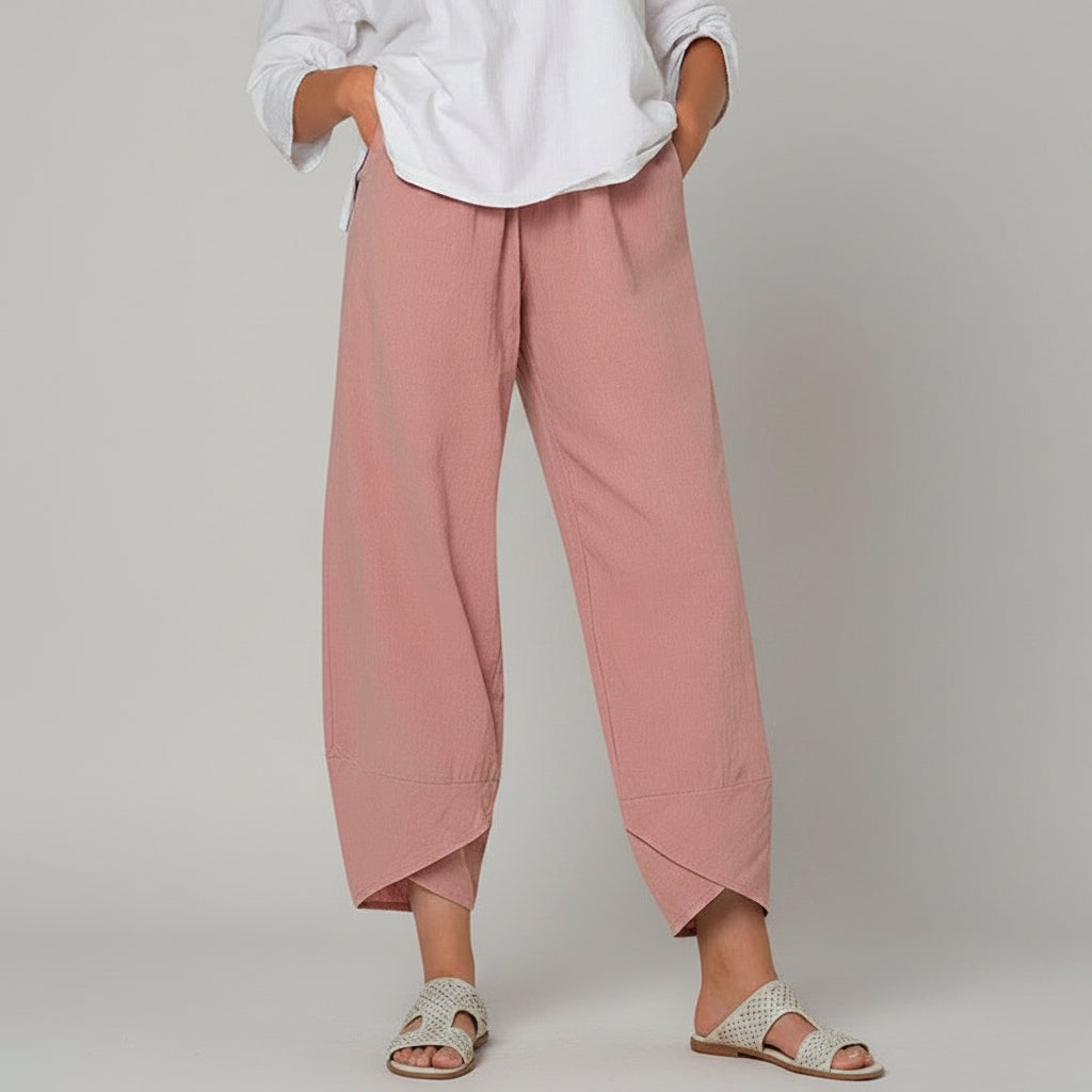 Person wearing pink pants and a white shirt on a white background