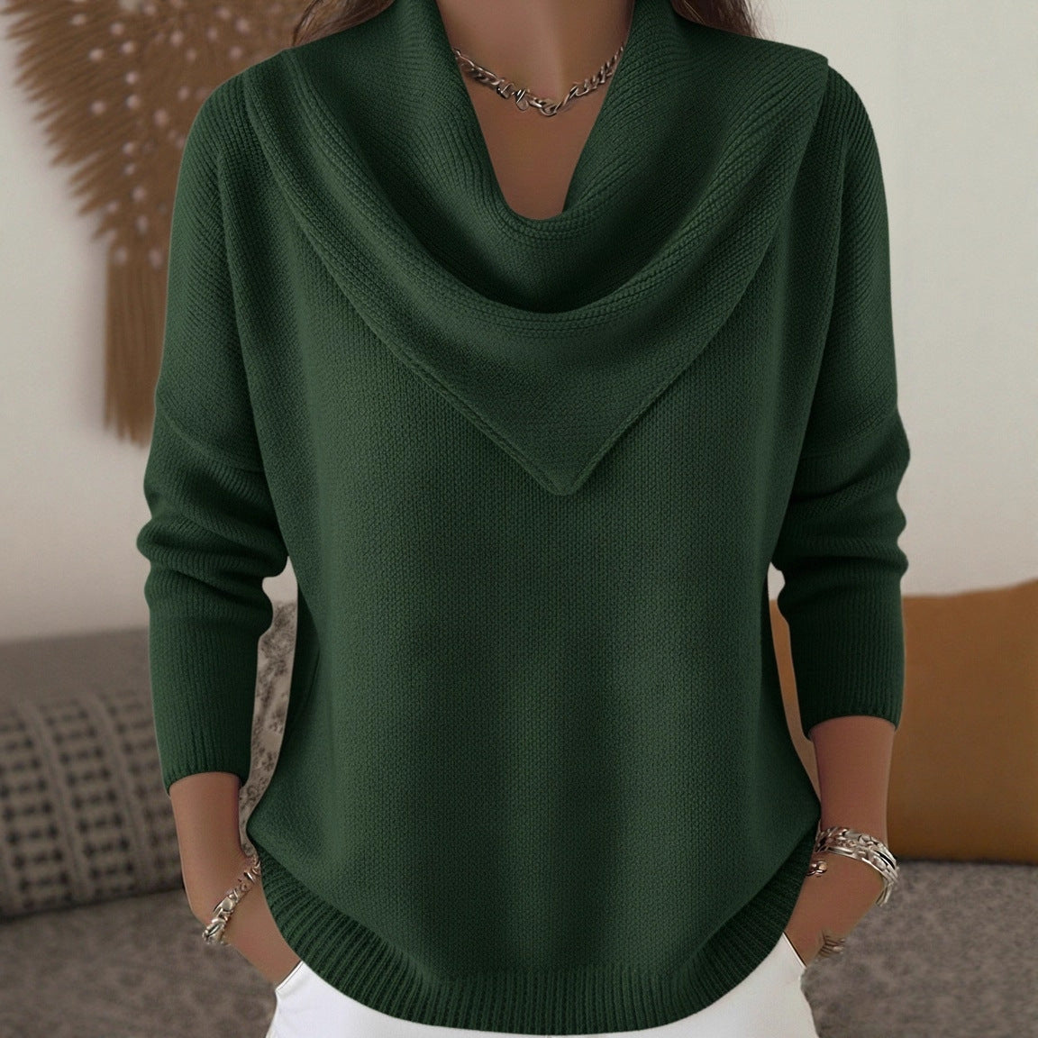 Green sweater worn by a person with a neutral background