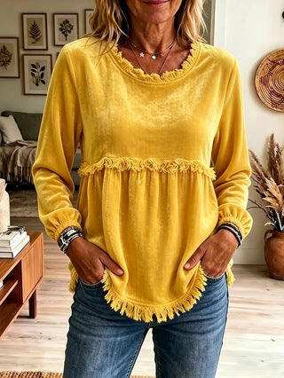 Person wearing a yellow top with ruffled details in a home setting