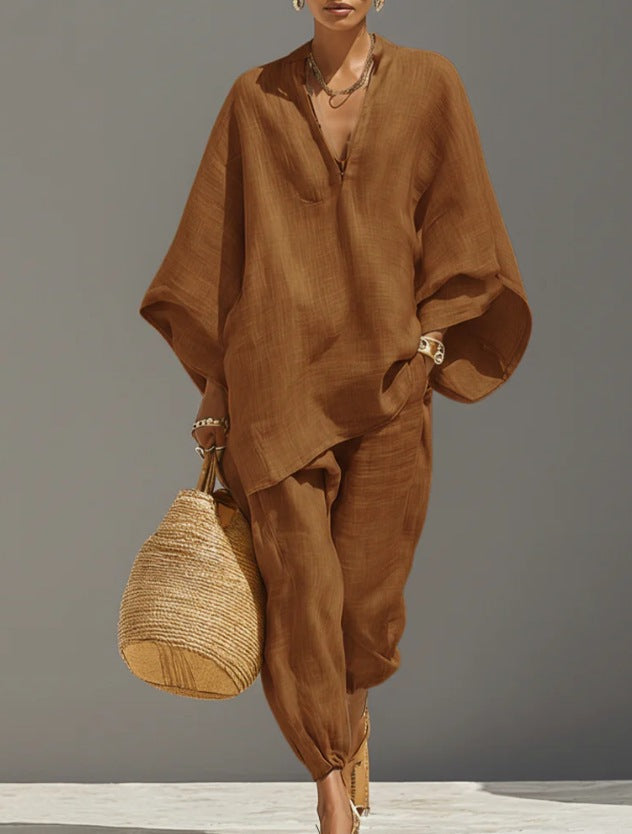 Person wearing a brown outfit holding a woven bag against a gray background
