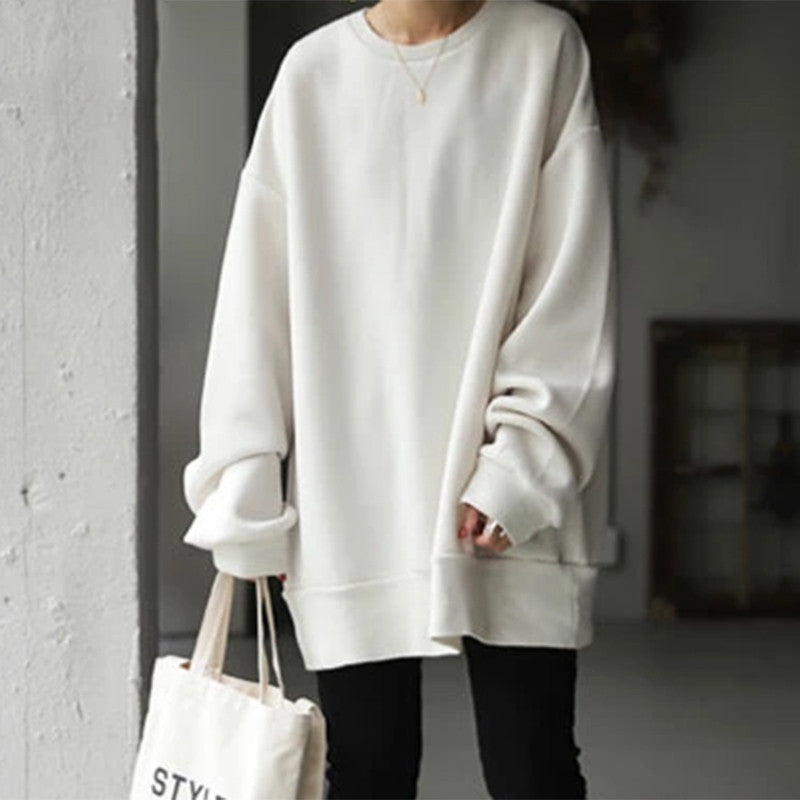 Person wearing a white oversized sweatshirt holding a tote bag with 'STYLE' text.