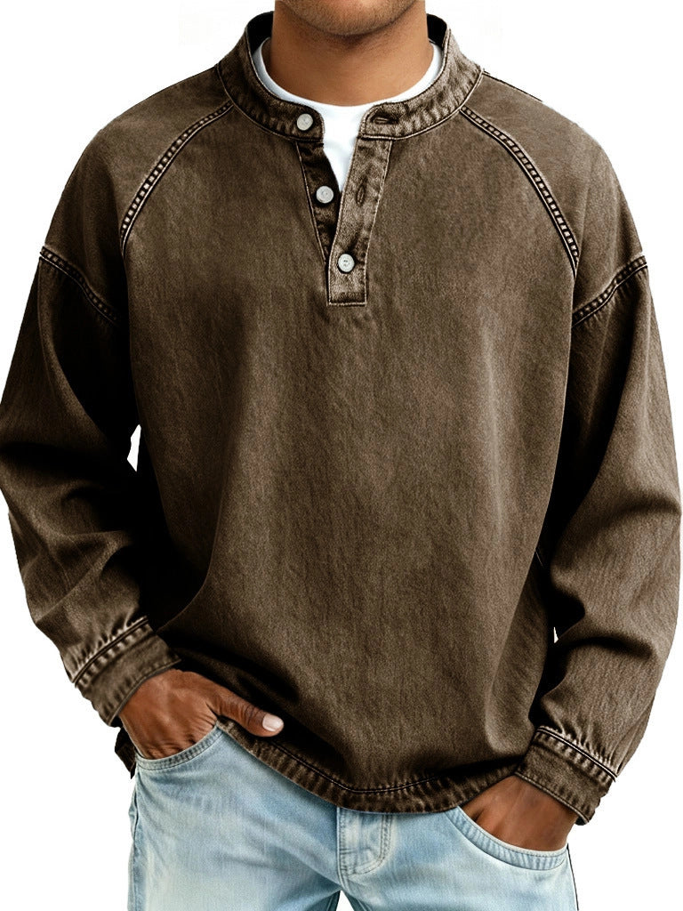 Man wearing a brown long-sleeve shirt with a collar, standing against a neutral background.