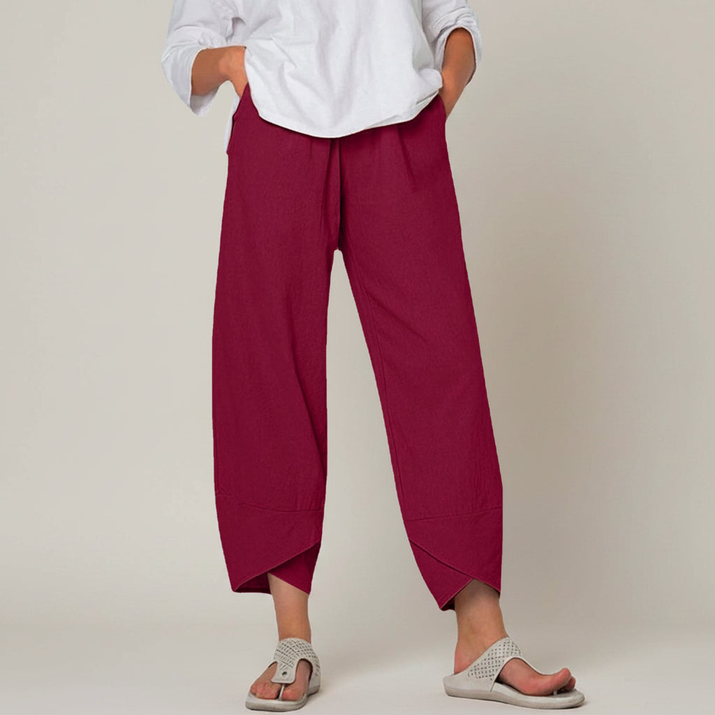 Person wearing maroon wide-leg pants and a white shirt on a white background