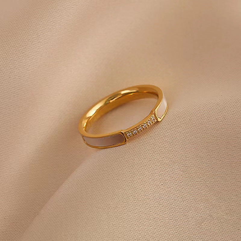 Gold ring with embedded stones on a beige fabric background