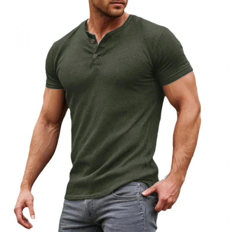 Man wearing a green henley shirt and gray jeans on a white background
