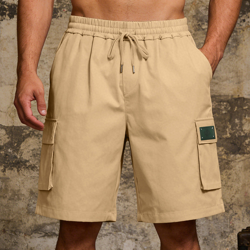 Beige cargo shorts with pockets on a textured background
