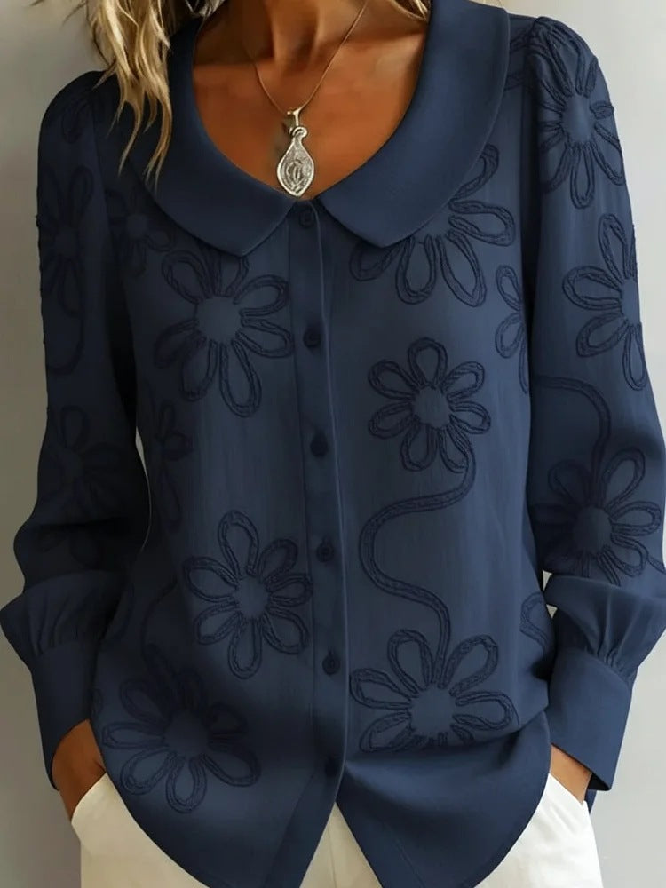 Navy blue blouse with floral patterns on a plain background