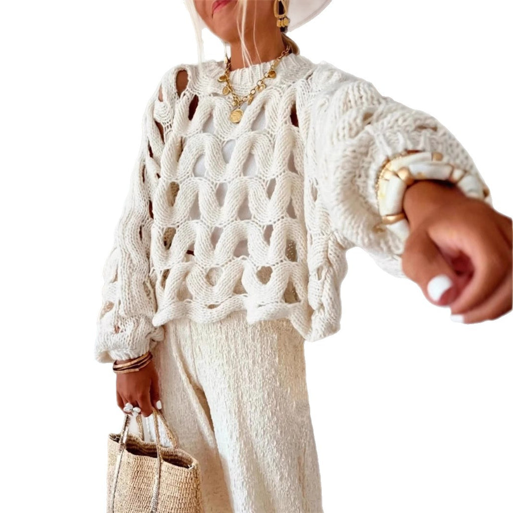 Person wearing a white textured sweater with gold jewelry on a white background