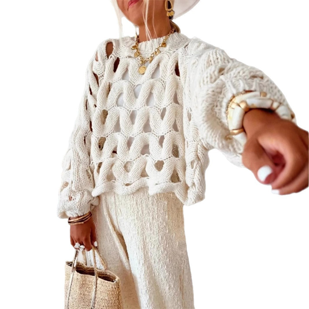 Person wearing a white textured sweater with gold jewelry on a white background