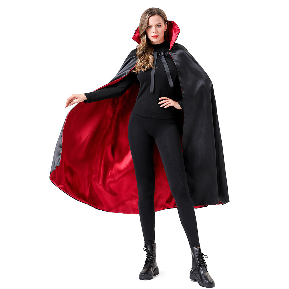 A woman modeling a black vampire cape with a shiny red satin lining, worn over a black outfit and boots against a plain white background.