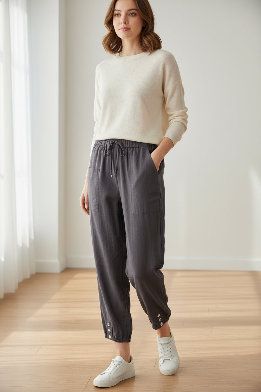 Dark gray cargo pants worn by models on a light wooden floor.