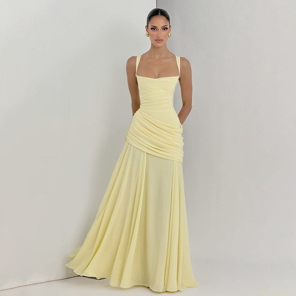 Woman wearing a light yellow evening gown against a plain background
