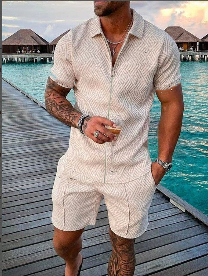 Man in a patterned beige outfit standing on a wooden dock by a body of water.