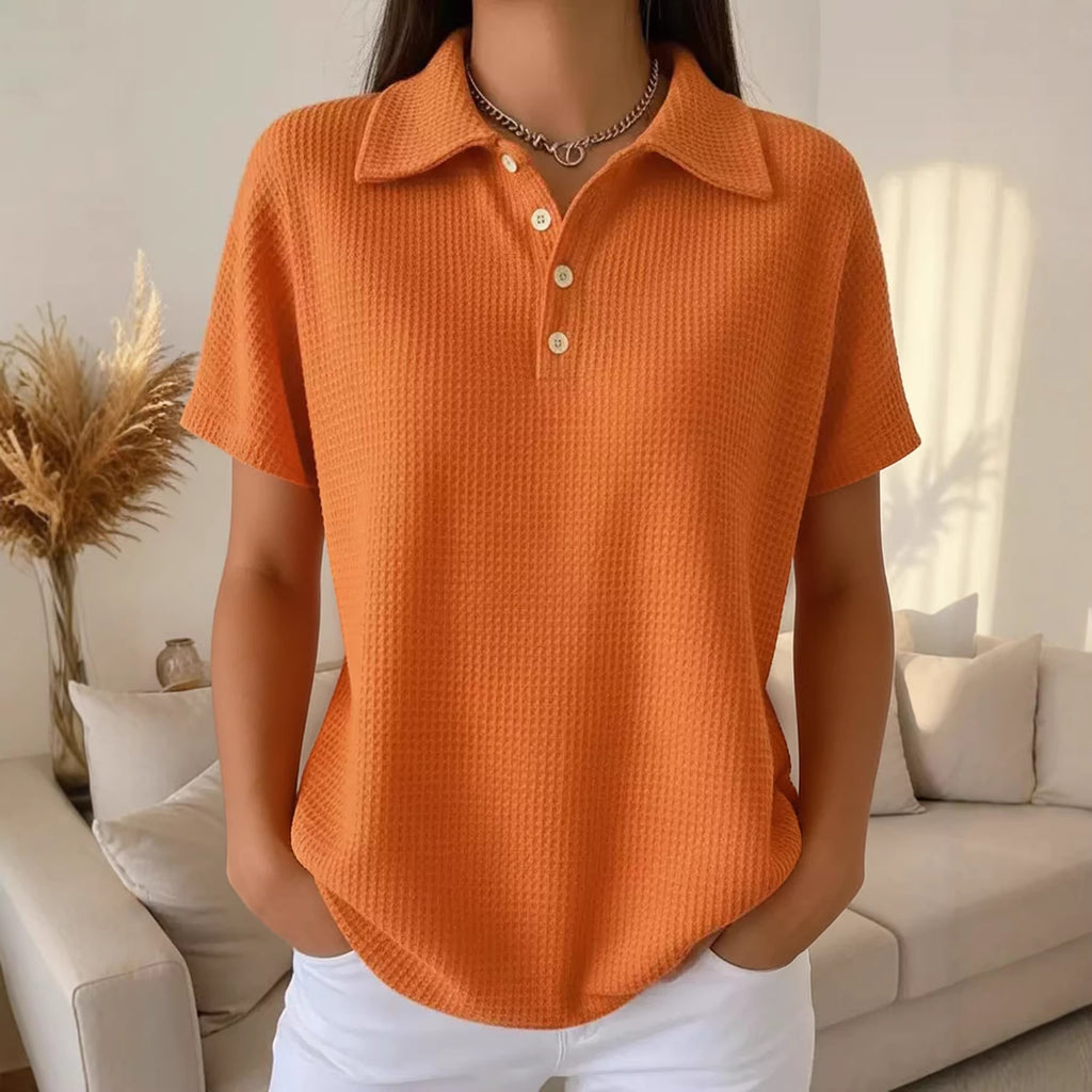 Person wearing an orange textured polo shirt in a living room setting