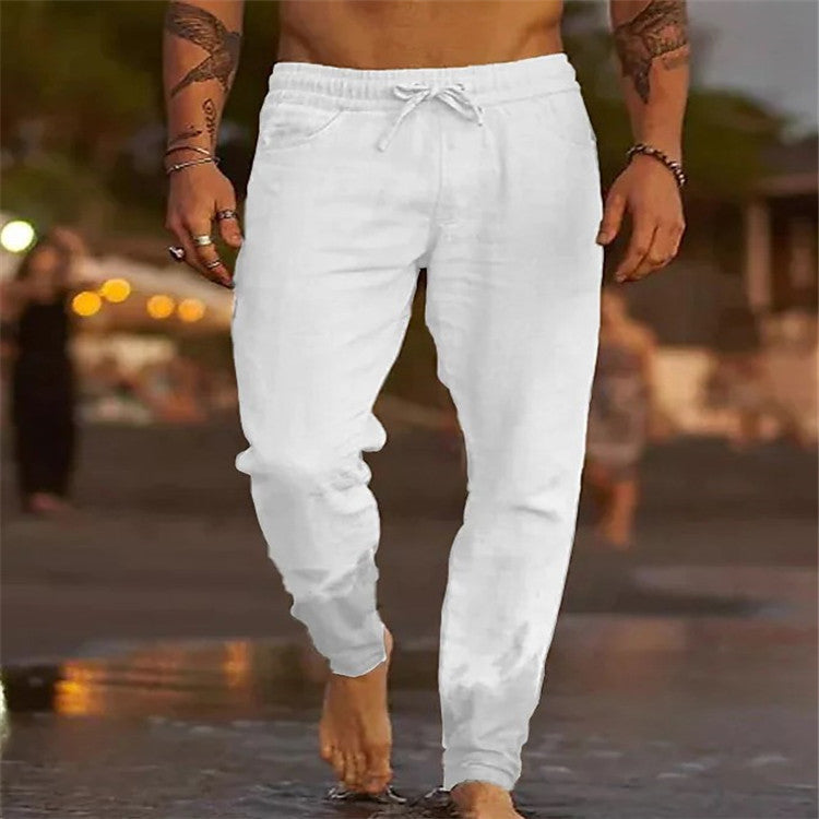Person wearing white jogger pants walking on a street with a blurred background