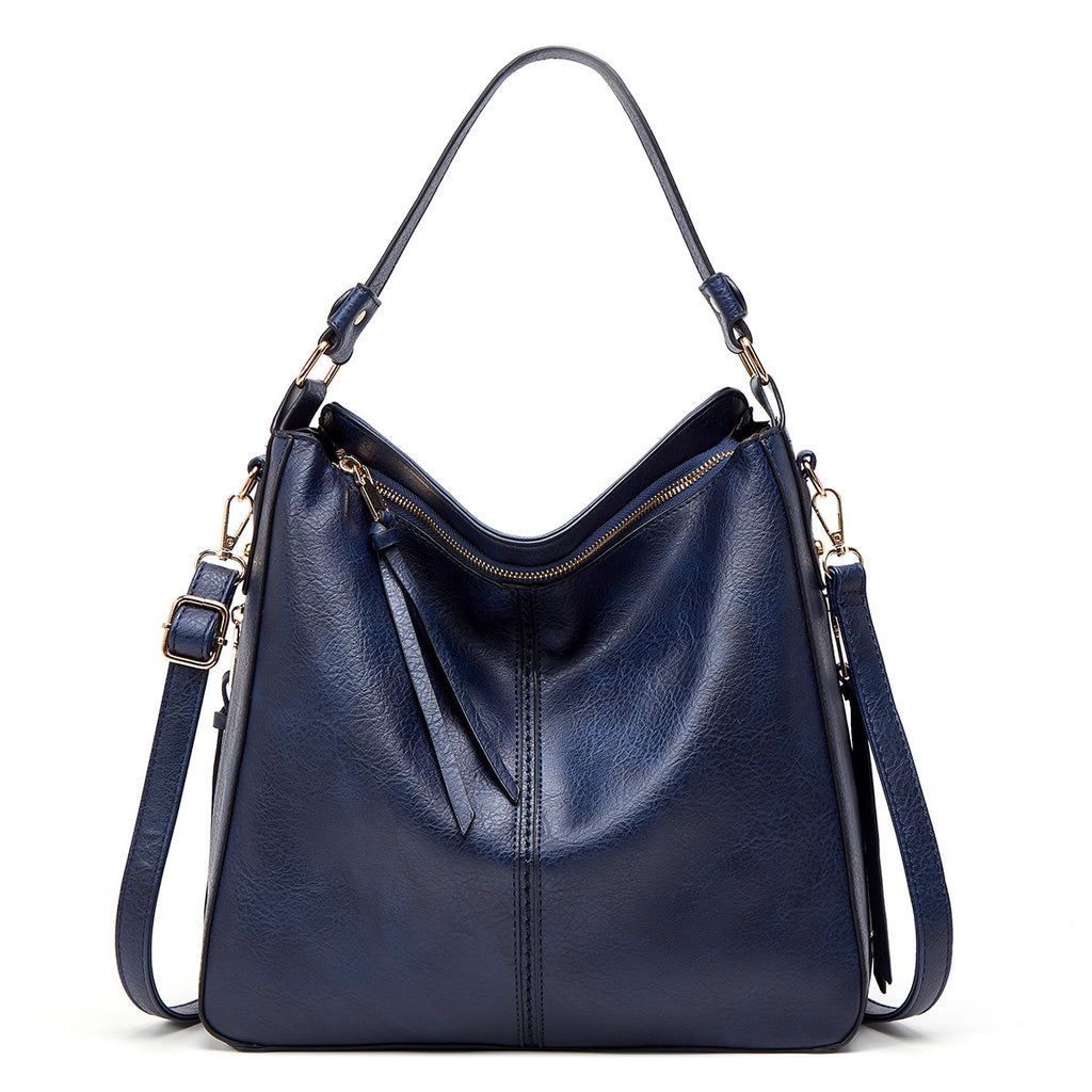 Navy blue handbag with gold zippers on a white background