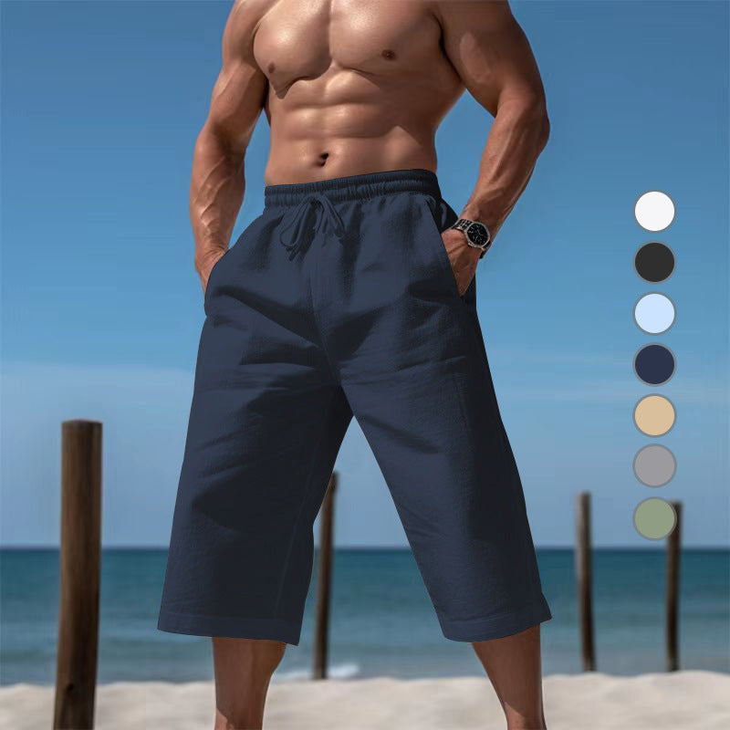 Man wearing navy shorts on a beach with color swatches.