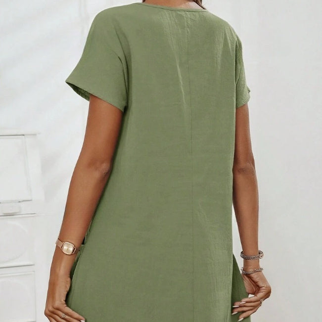Person wearing a green dress with a plain background