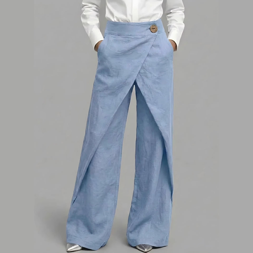 Light blue wide-leg pants worn with a white shirt on a gray background