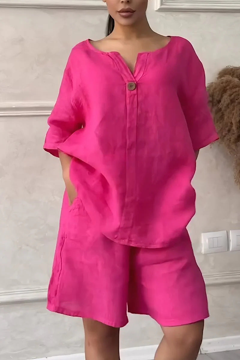 Person wearing a bright pink outfit with a matching top and shorts against a neutral background.