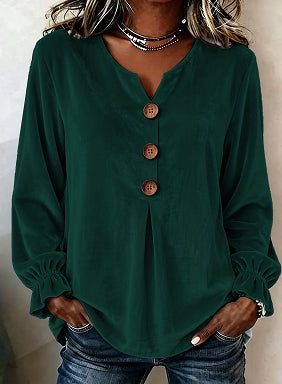 Green long-sleeve top with buttons worn by a person against a neutral background