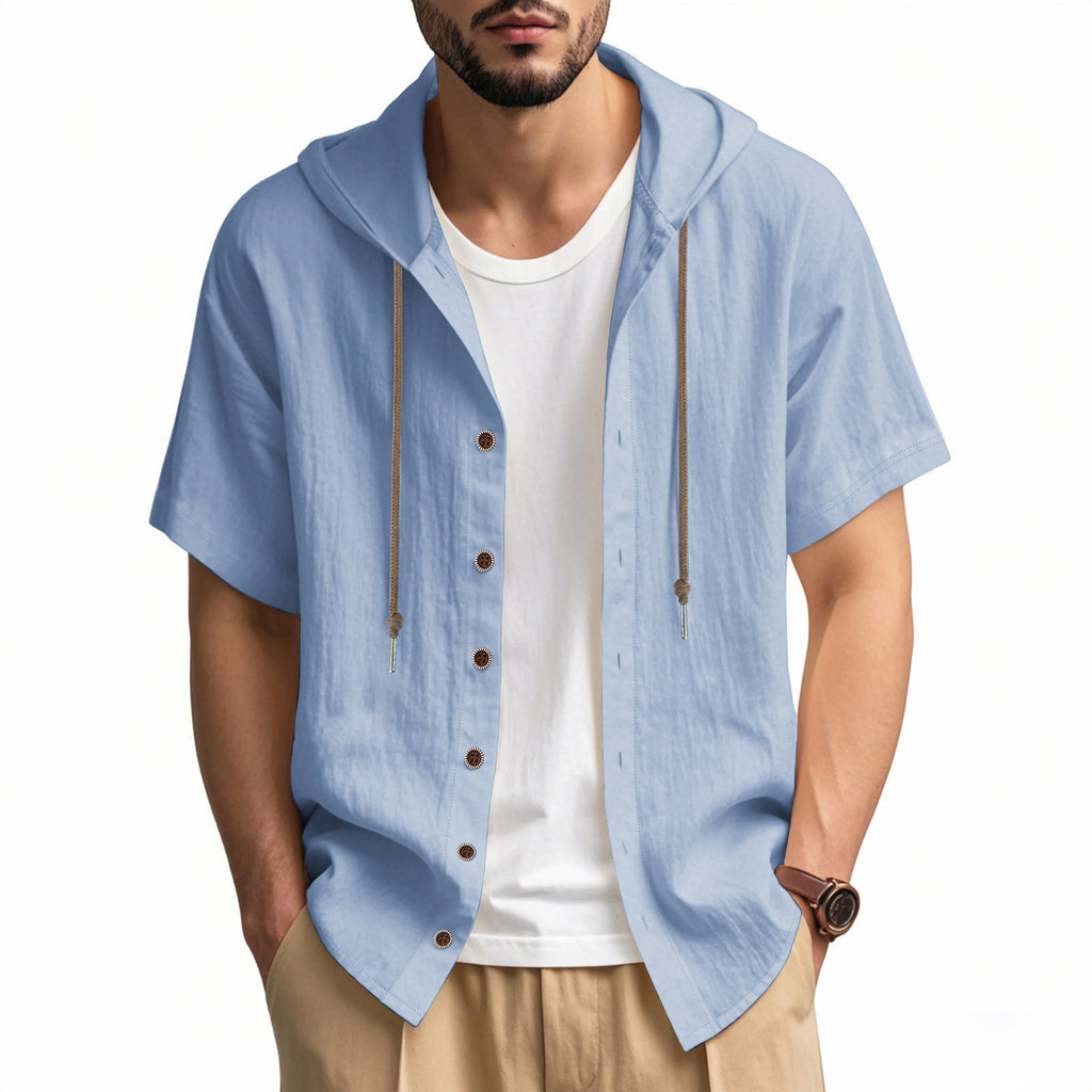 Man wearing a light blue short-sleeve button-up shirt over a white t-shirt on a white background