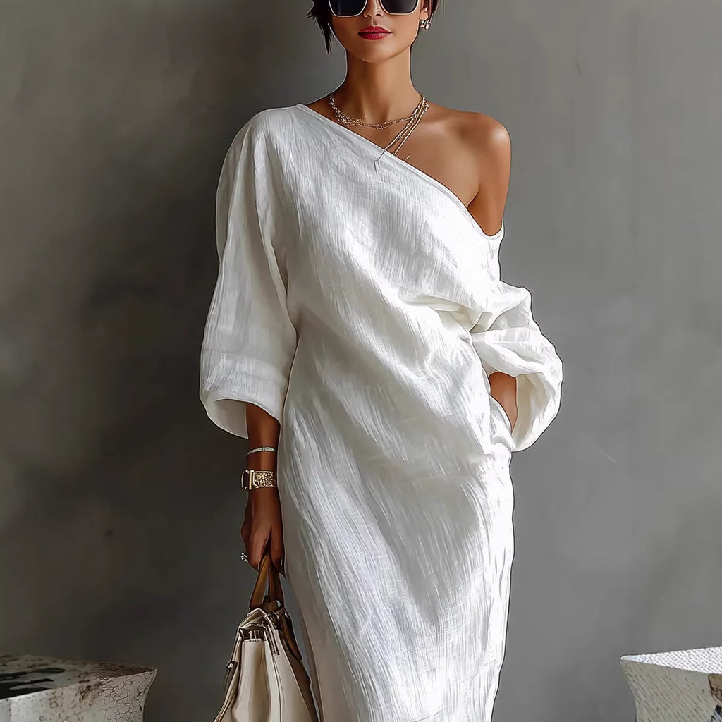 Woman wearing a white one-shoulder dress against a gray background