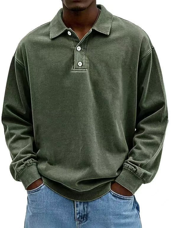 Person wearing a green long-sleeve polo shirt with rolled-up sleeves and blue jeans.