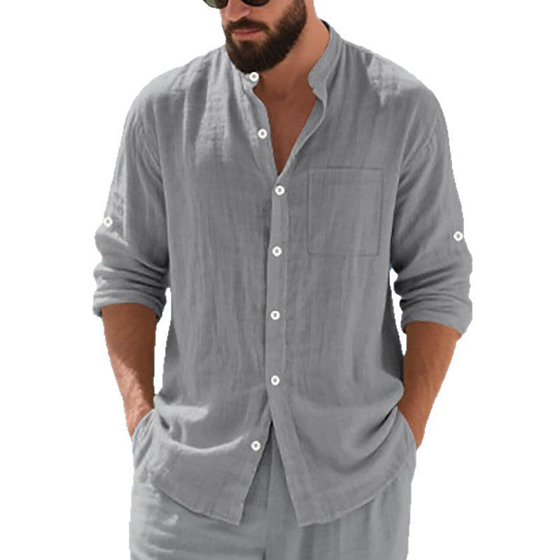 Man wearing a gray button-up shirt and pants on a white background