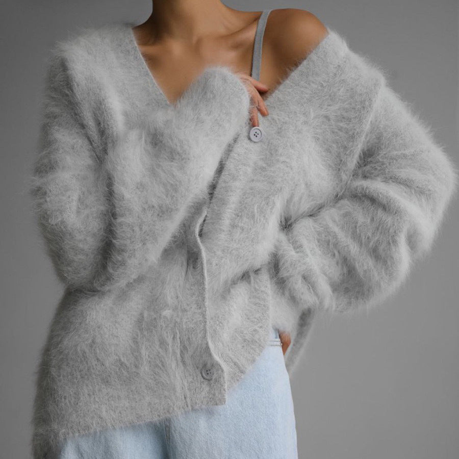 Gray fluffy cardigan worn by a person on a gray background