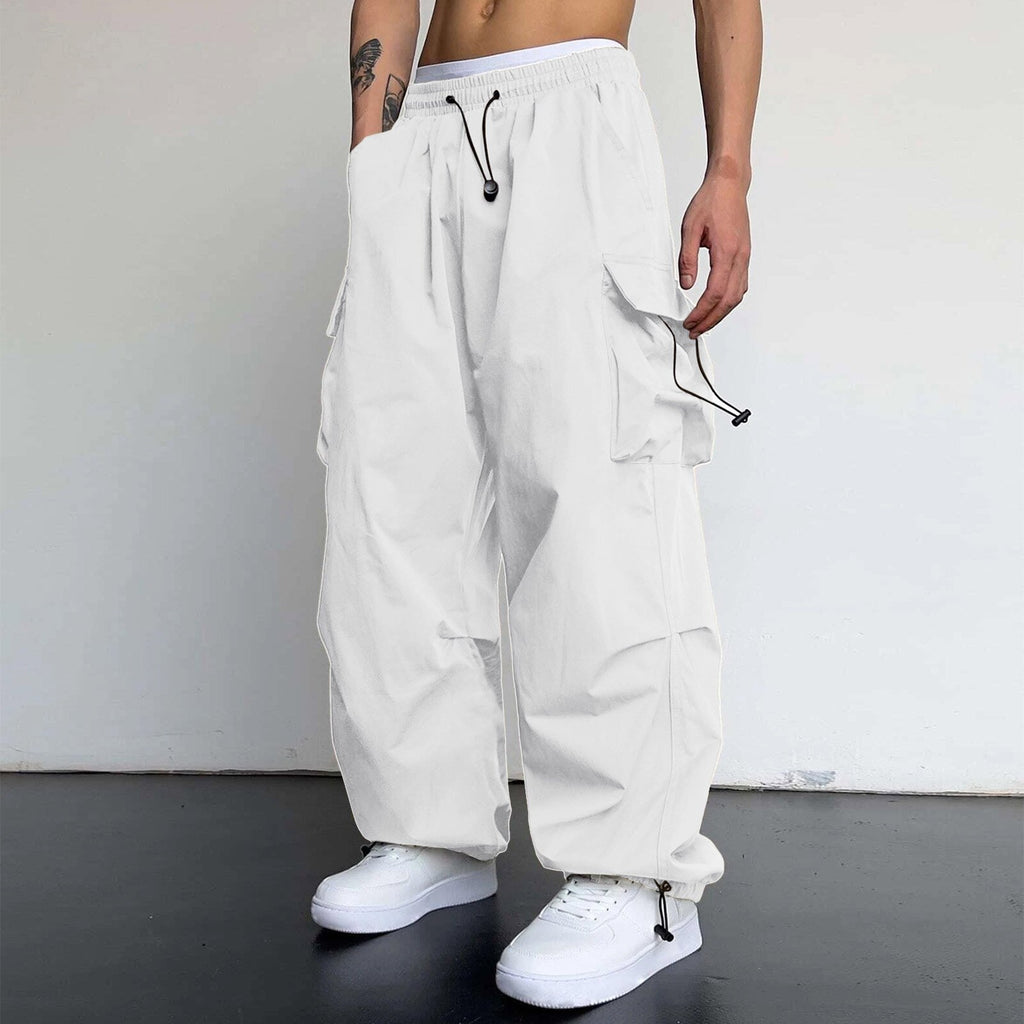 Person wearing white cargo pants with a plain background