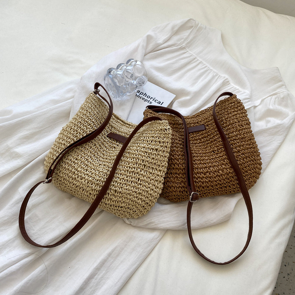 Two woven handbags with brown straps on a white fabric background