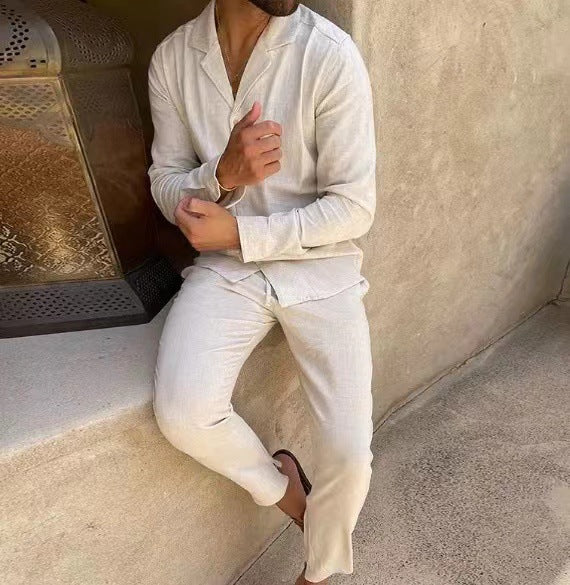 Person wearing a white outfit sitting against a textured wall.