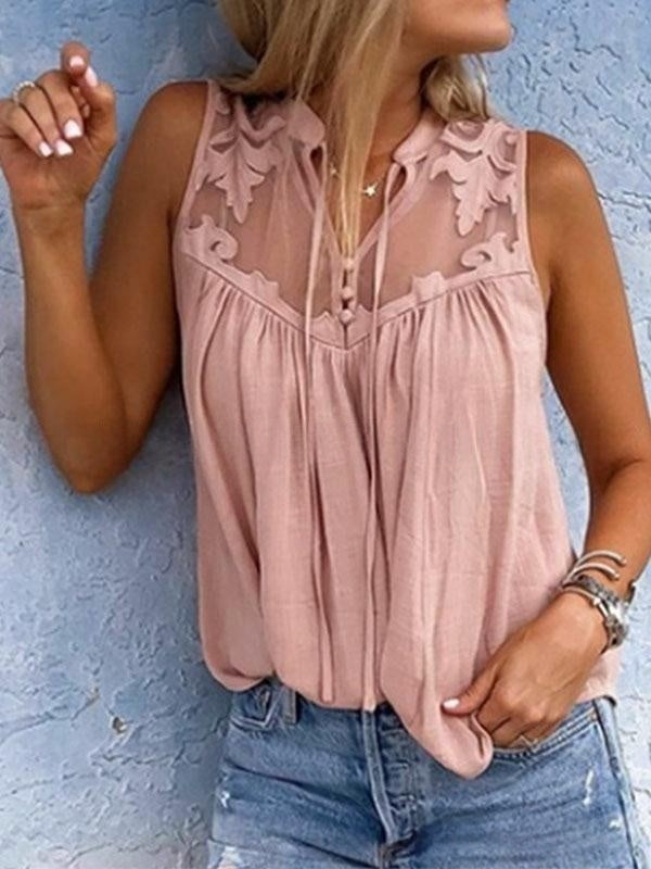 Woman wearing a pink lace top against a blue wall