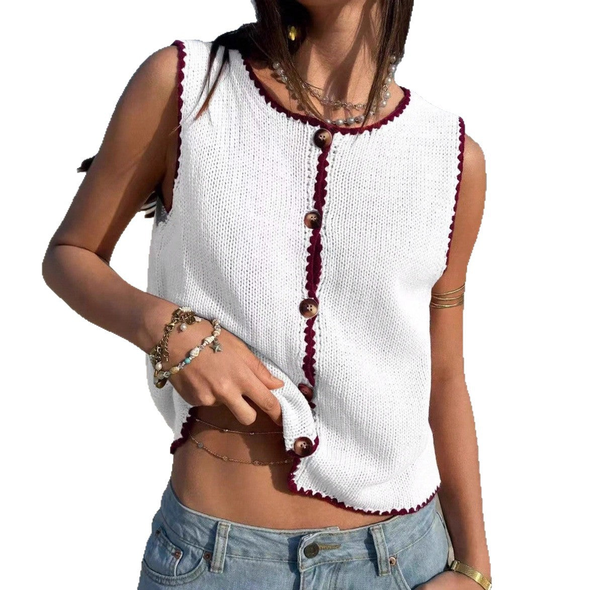 Woman wearing a white sleeveless top with red trim and blue jeans on a white background
